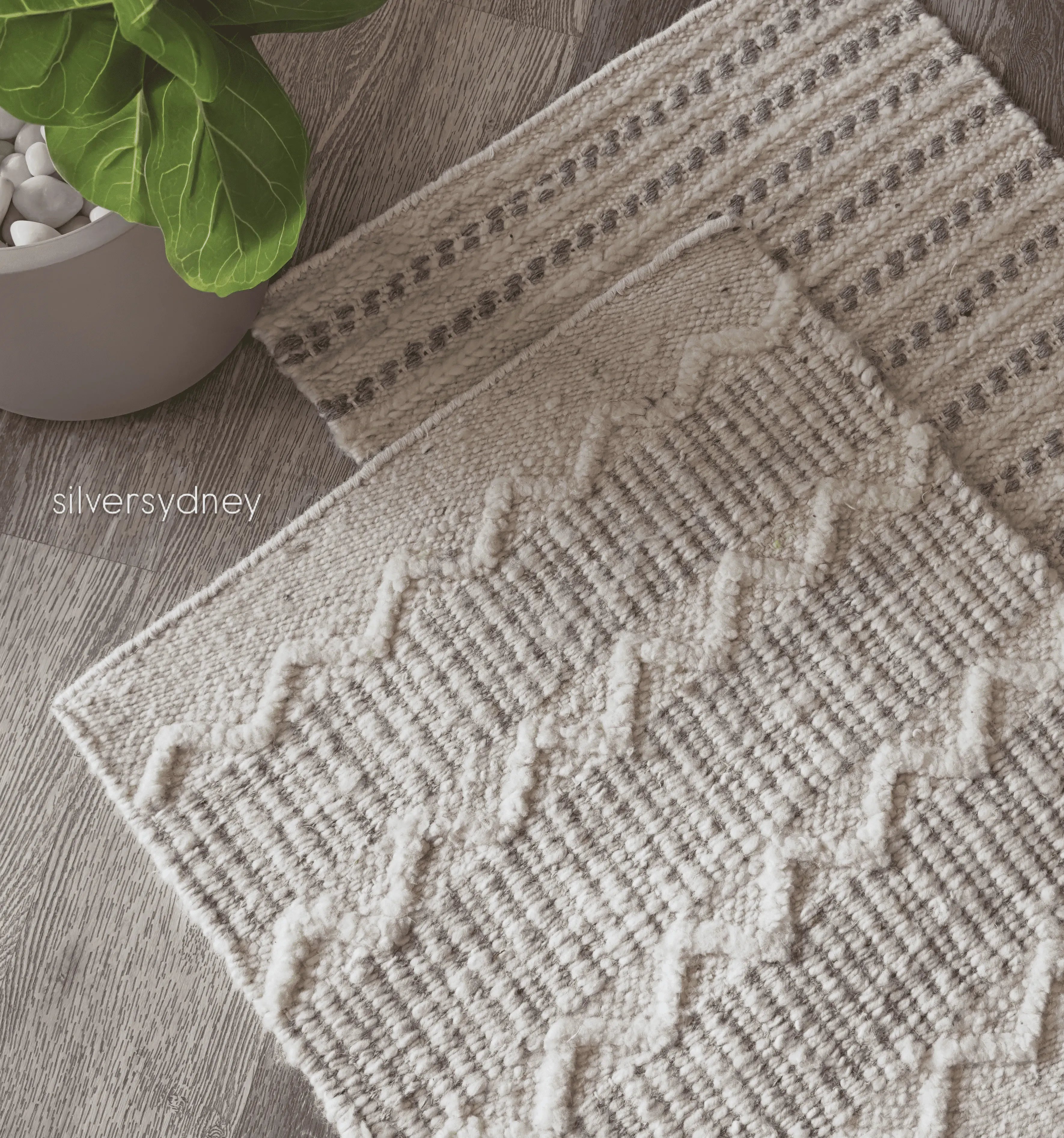 Handwoven ivory and grey wool runner rug with diamond pattern beside a fiddle leaf fig plant on a wood floor