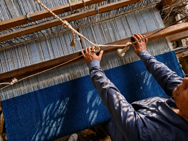 Skilled artisan hand-weaving a premium rug using traditional loom techniques in India